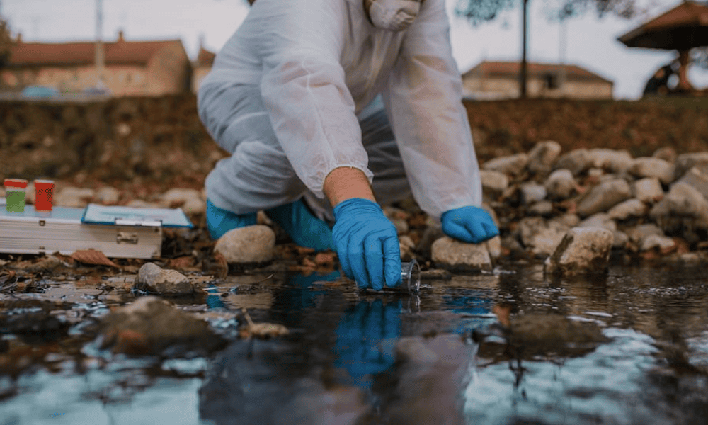 Contractors Pollution Liability vs. Pollution Liability - Person In Protective Gear Taking Water Samples